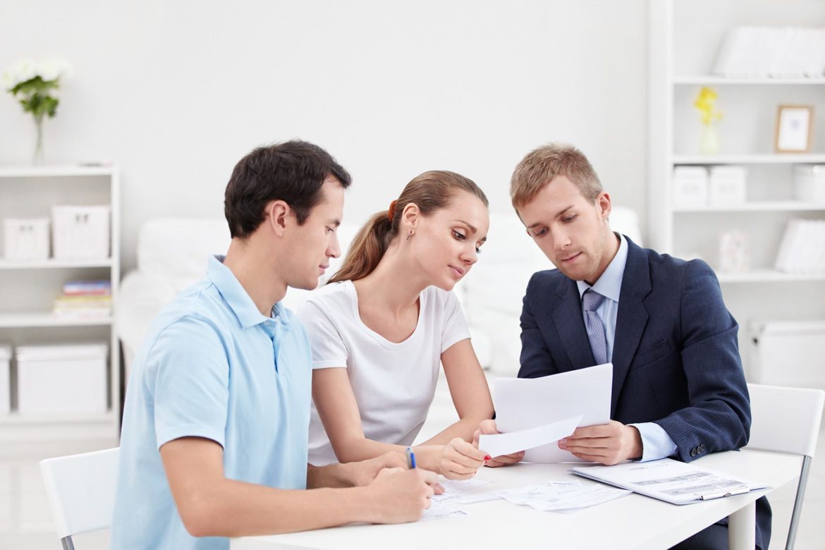 A couple of people sitting at a table with papers