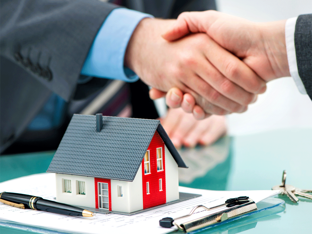 Two people shaking hands over a house.