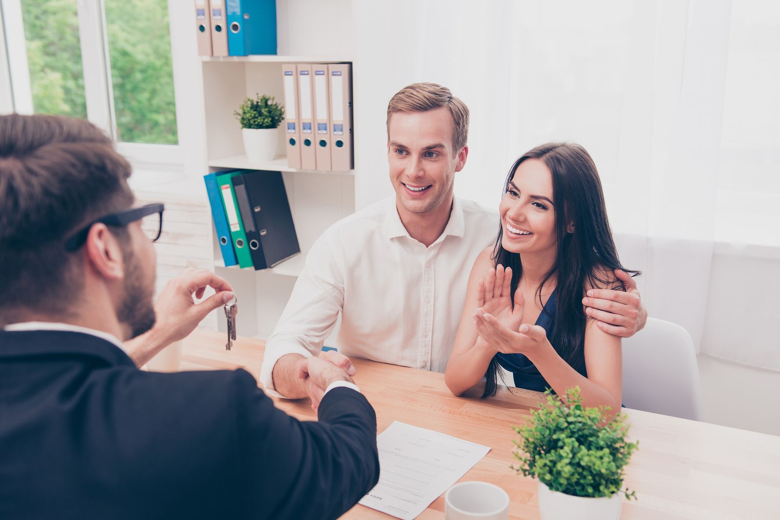 A couple is sitting at the table with an agent.