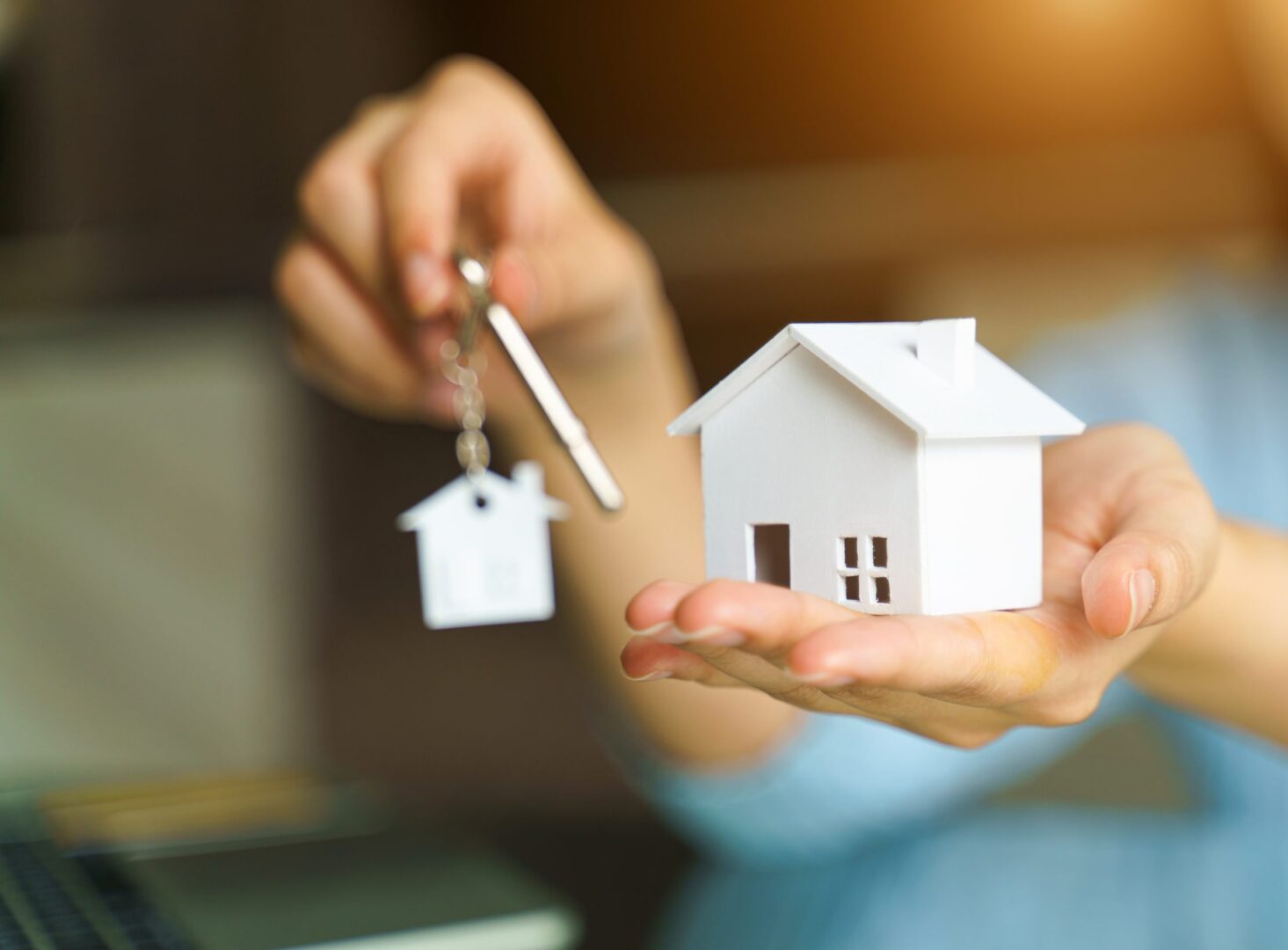 A person holding a key and a house