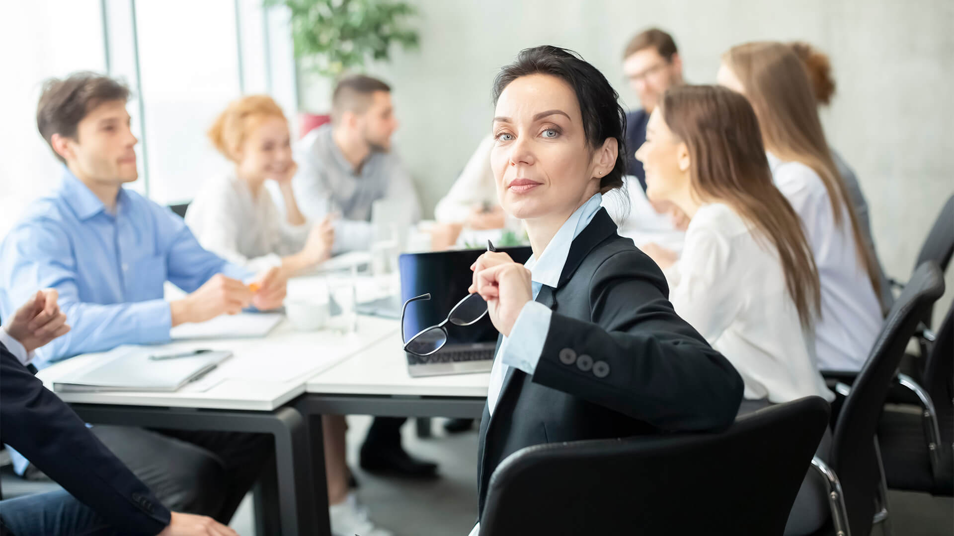 A woman sitting at a table with other people.