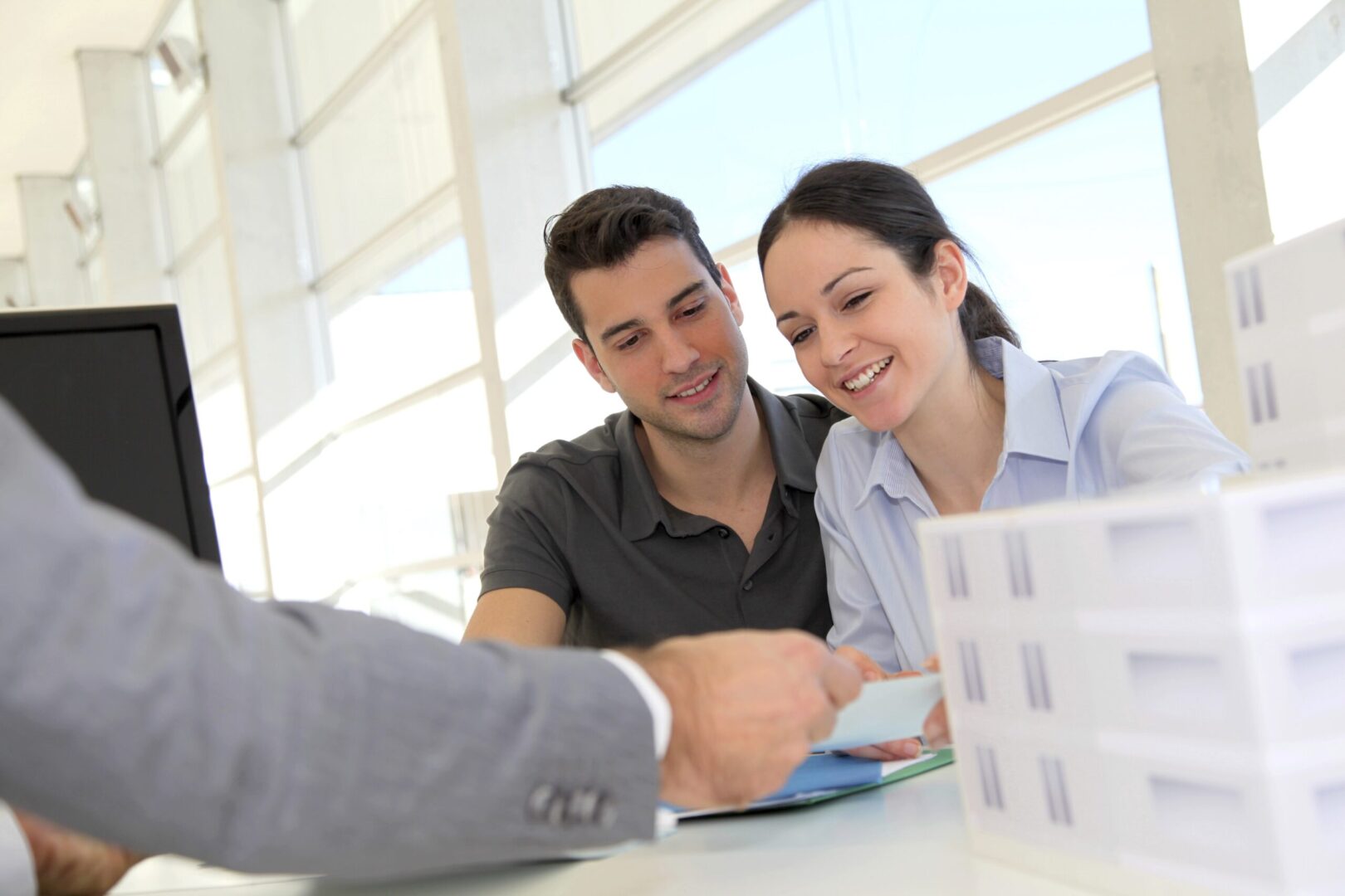 A man and woman sitting at a table with papers.