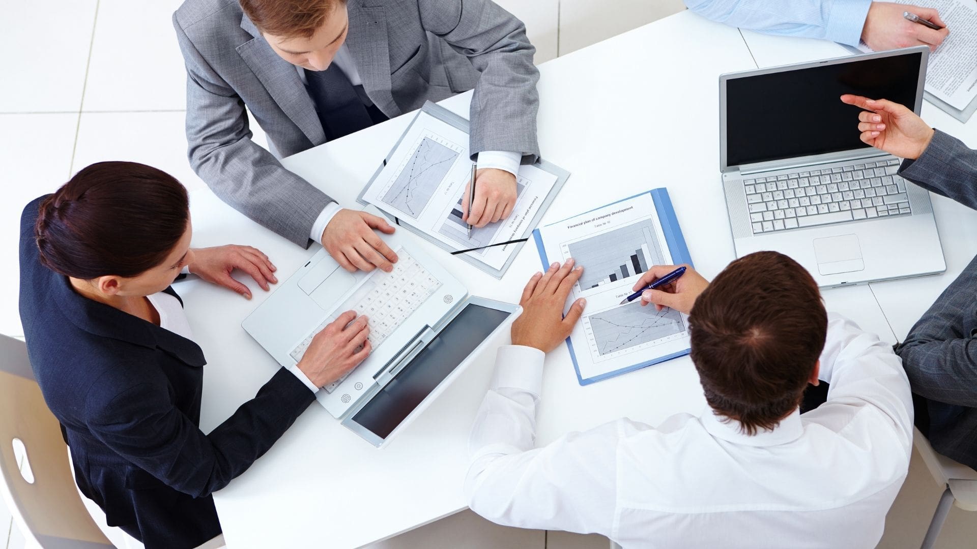 A group of people sitting around a table with papers.