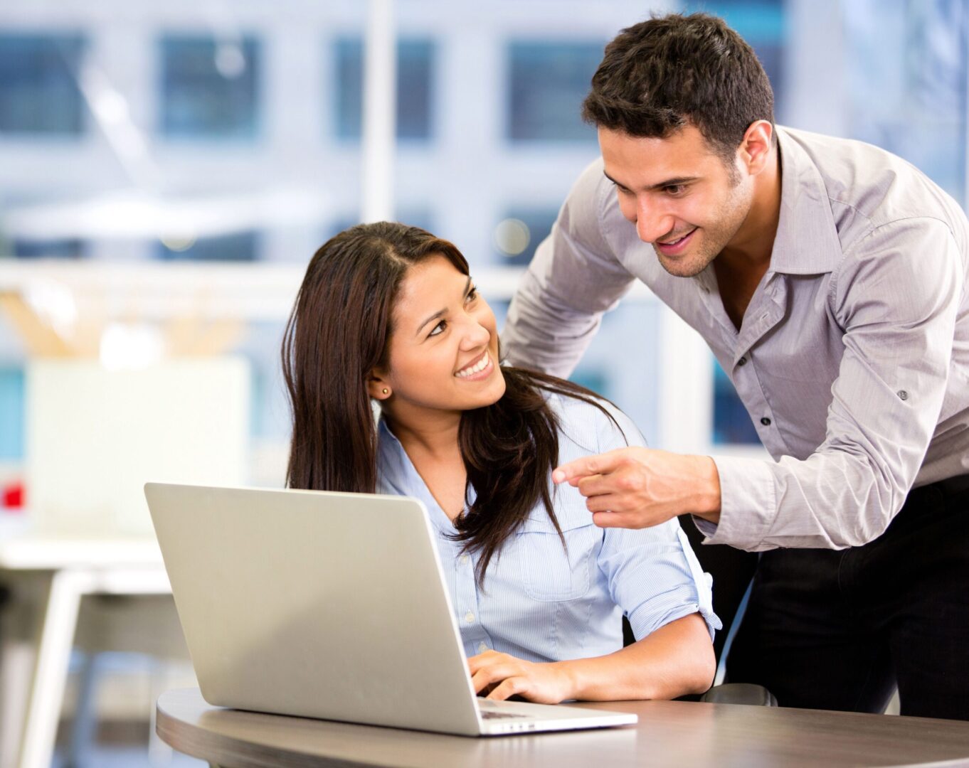 A man and woman are looking at the laptop.