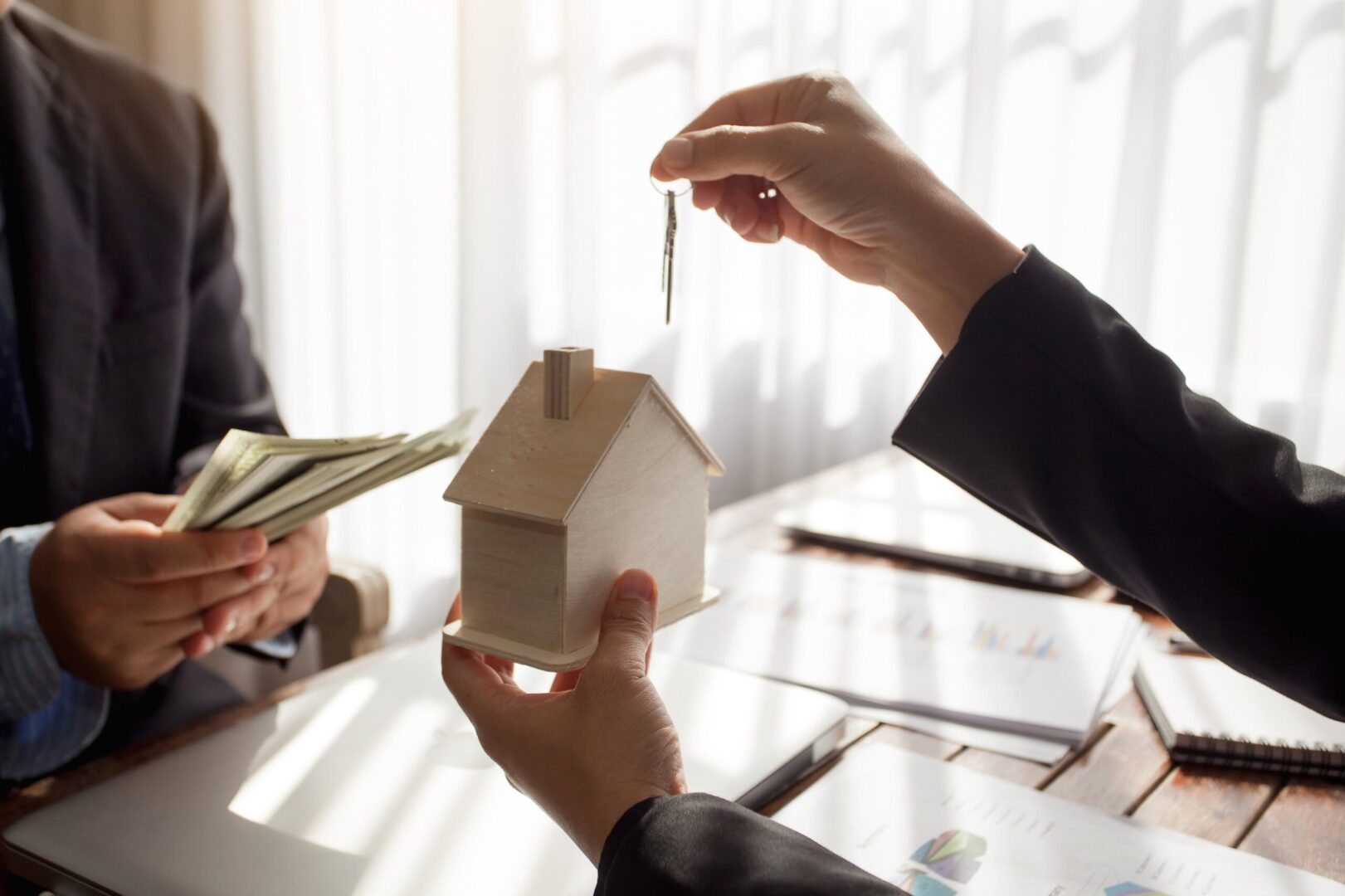 A person holding a key and a house