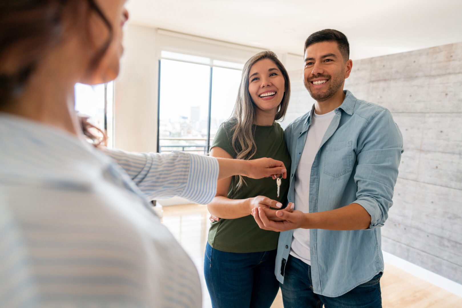 A couple is holding keys to their new home.