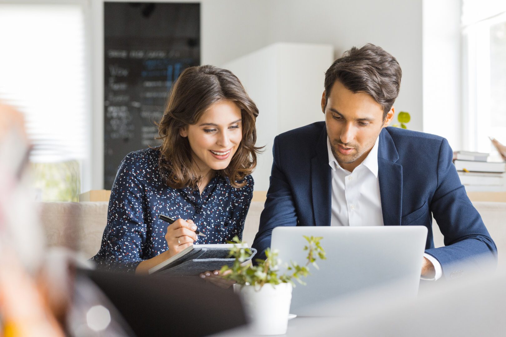 A man and woman looking at a laptop