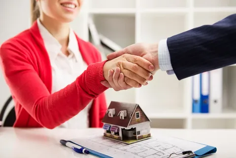 A woman shaking hands with an agent.