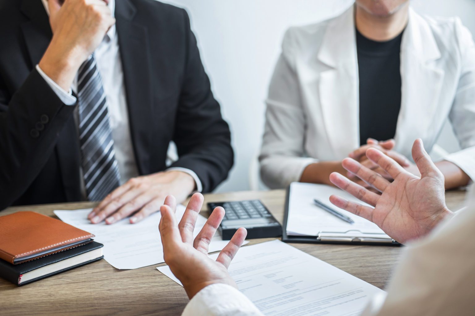 A group of people sitting at a table with papers.