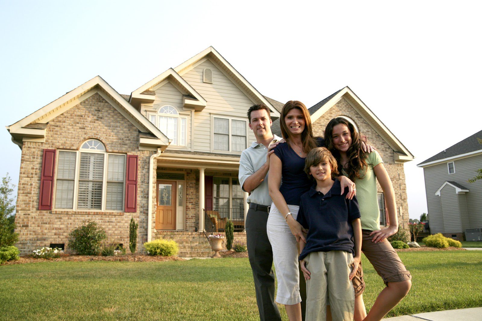 A family poses in front of their new home.