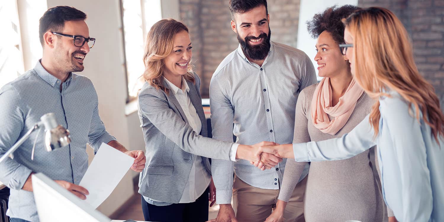 A group of people shaking hands in an office.