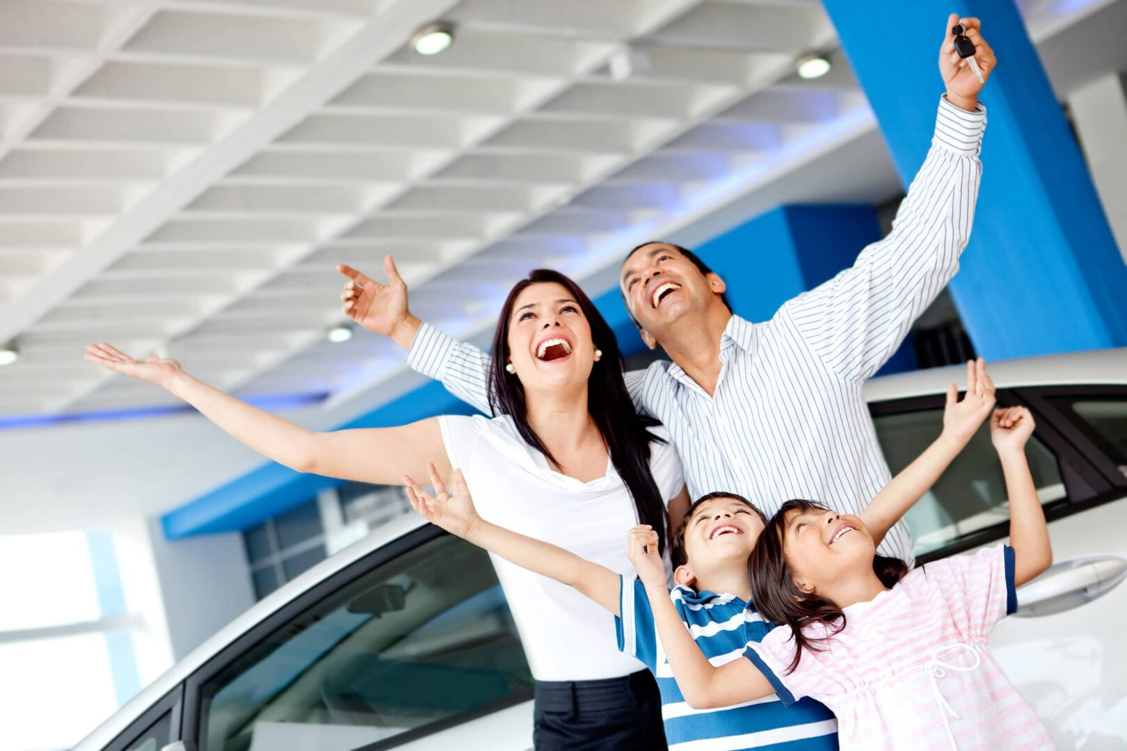 A family is celebrating in the showroom of their car.