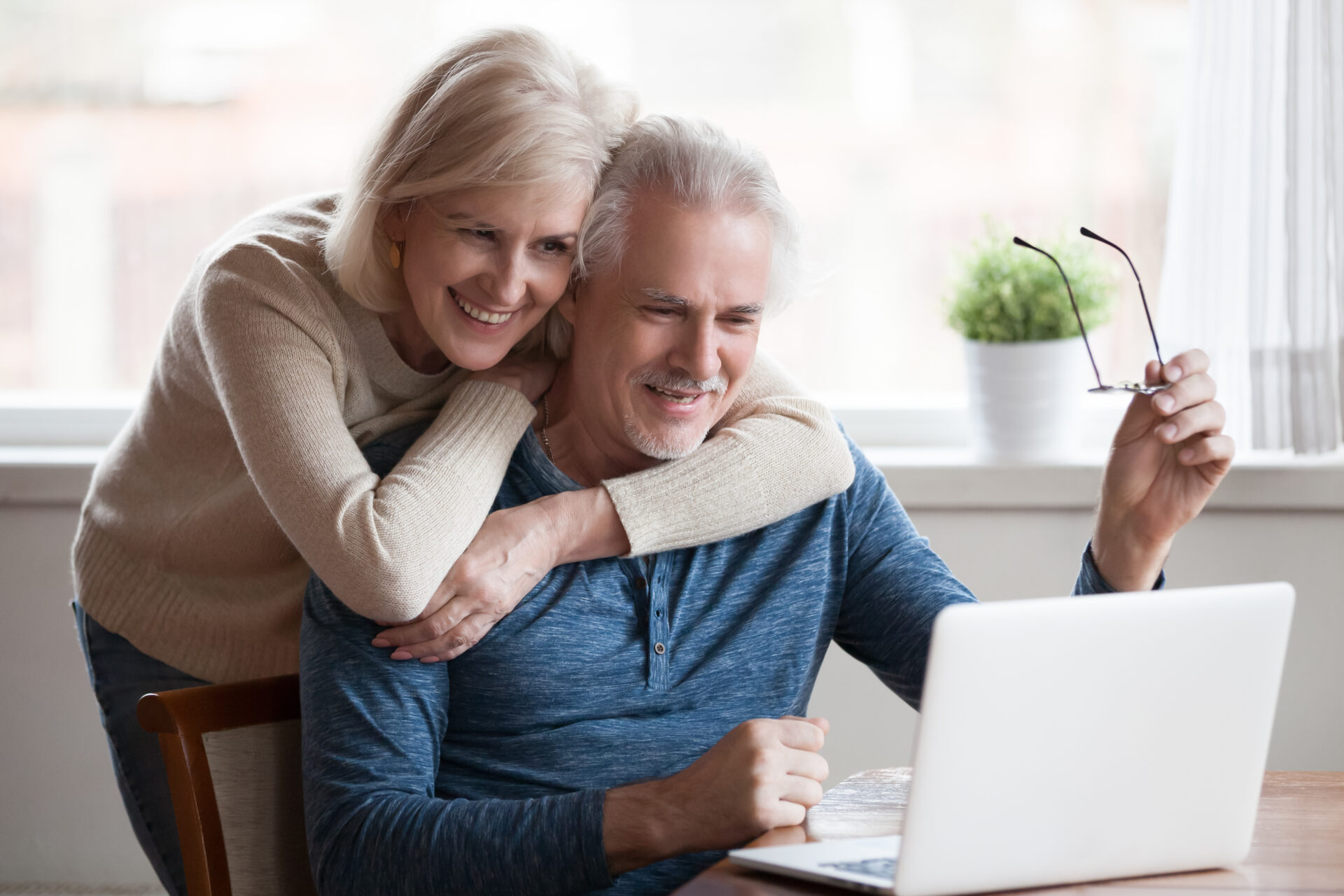 A couple in front of the laptop smiling