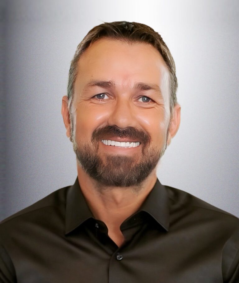 Steven wearing black shirt standing in front of a white wall